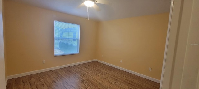 spare room with ceiling fan, baseboards, and wood finished floors