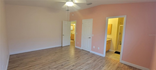 unfurnished bedroom with visible vents, ensuite bathroom, vaulted ceiling, light wood-type flooring, and baseboards