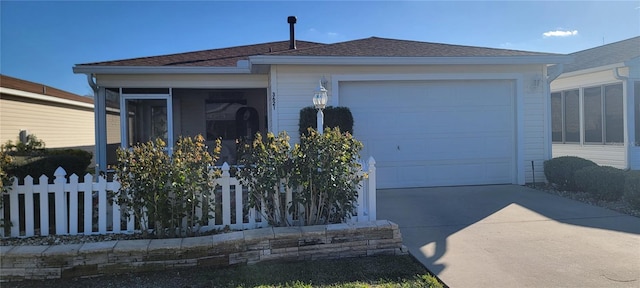 ranch-style house featuring driveway, fence, and a sunroom