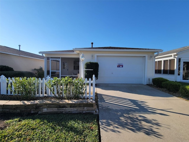 view of front of home featuring driveway, a sunroom, and an attached garage