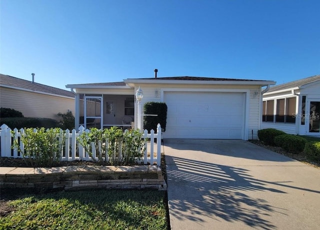 view of front of property with an attached garage, a sunroom, fence, and concrete driveway