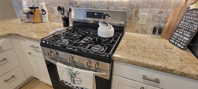 3621 Amelia Ave, The Villages, FL 32162 - kitchen featuring stainless steel range with gas stovetop, backsplash, white cabinetry, and light stone countertops