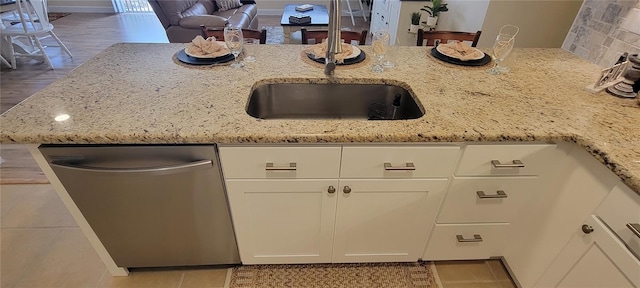 3621 Amelia Ave, The Villages, FL 32162 - kitchen with stainless steel dishwasher, light stone countertops, white cabinetry, and tile patterned floors