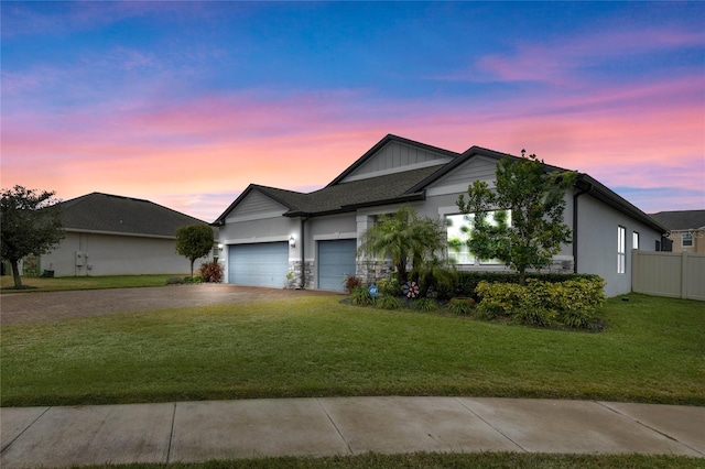 single story home featuring a garage and a lawn