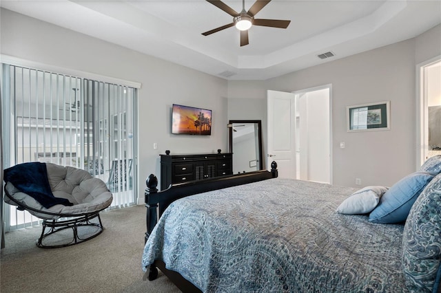 bedroom with carpet floors, access to outside, ceiling fan, and a tray ceiling