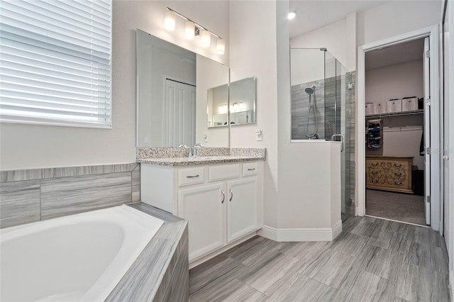 bathroom featuring independent shower and bath and vanity