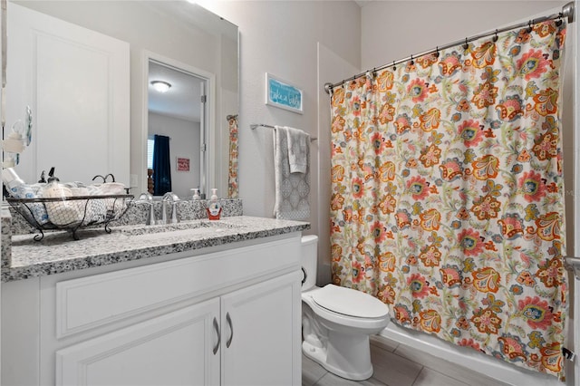 bathroom with tile patterned flooring, vanity, toilet, and walk in shower