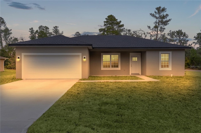 view of front of home with a garage and a lawn