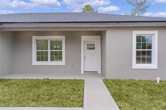 property entrance with a lawn