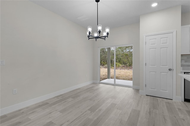 unfurnished dining area with a chandelier and light wood-type flooring