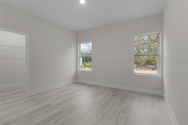 spare room with plenty of natural light and light hardwood / wood-style floors