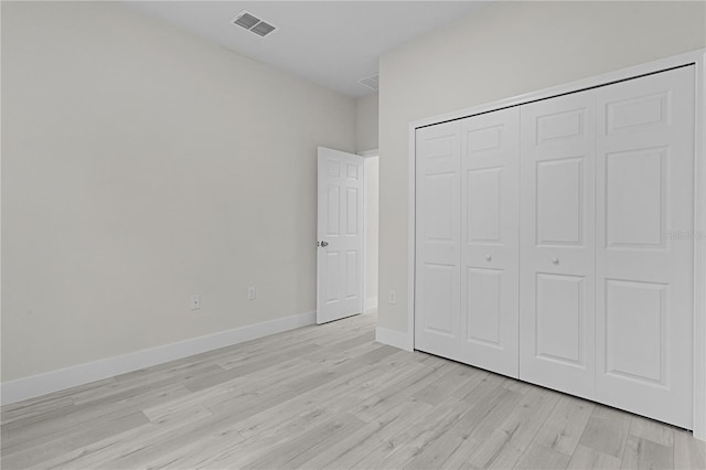 unfurnished bedroom with light hardwood / wood-style flooring and a closet