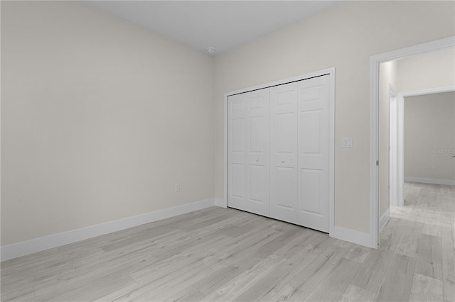 unfurnished bedroom featuring light hardwood / wood-style floors and a closet