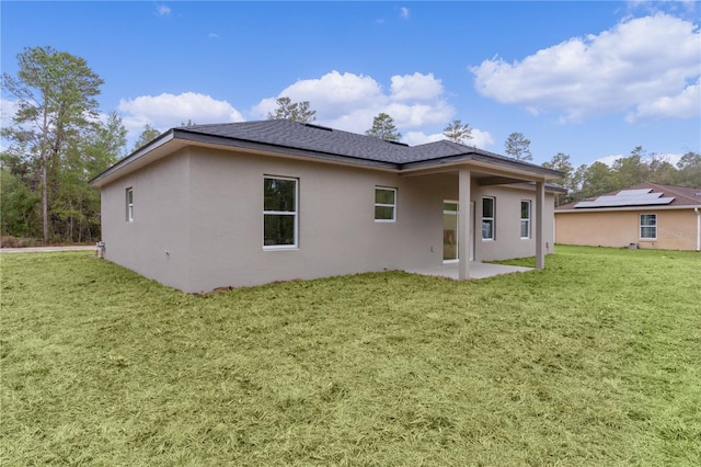 rear view of property with a lawn and a patio area