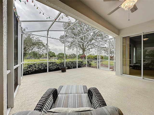 view of patio featuring a ceiling fan and a lanai