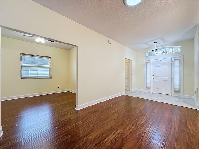 entryway with dark wood-style floors, a ceiling fan, baseboards, and a textured ceiling