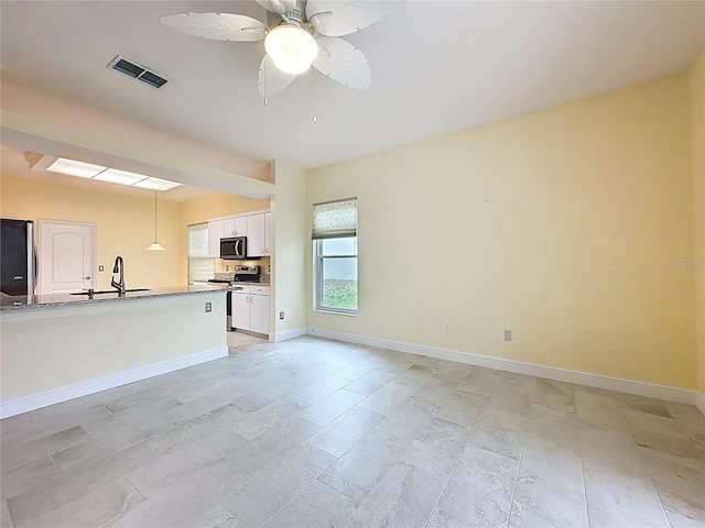 kitchen featuring stainless steel appliances, visible vents, hanging light fixtures, white cabinets, and baseboards