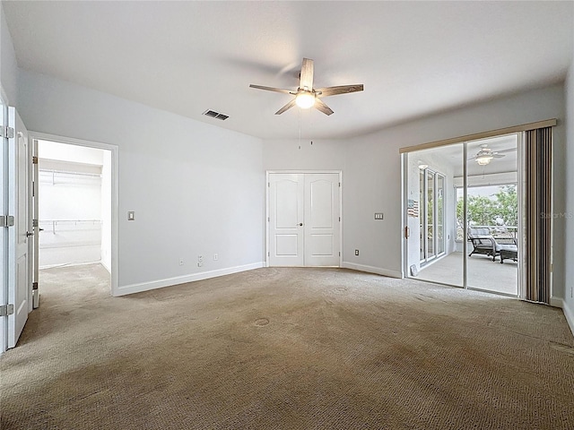 empty room with ceiling fan, carpet, visible vents, and baseboards