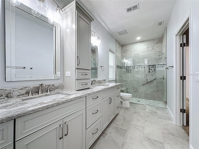 full bathroom featuring toilet, a shower stall, visible vents, and a sink