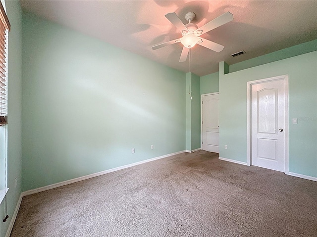 unfurnished bedroom featuring ceiling fan, carpet floors, visible vents, and baseboards