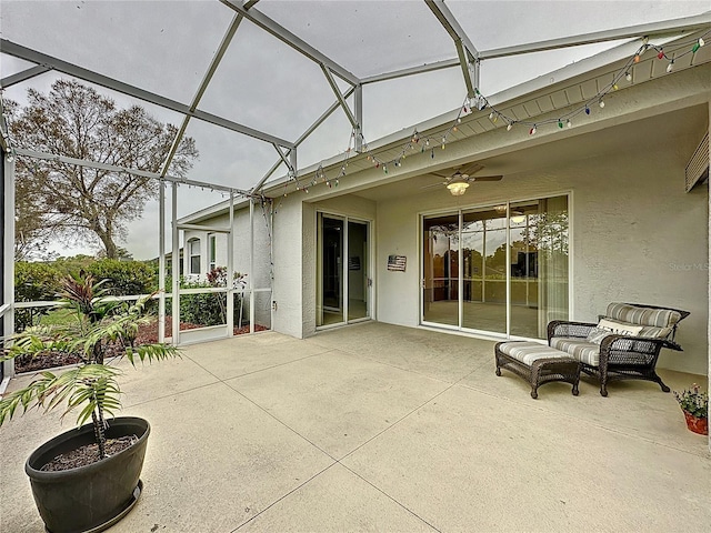 view of patio with ceiling fan and a lanai