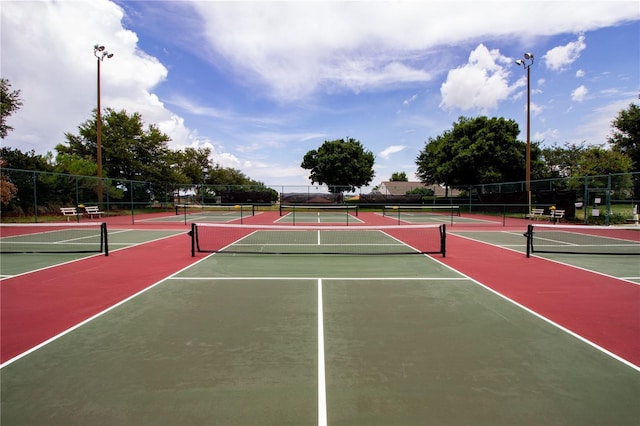 view of tennis court featuring community basketball court and fence