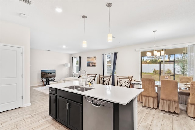 kitchen featuring sink, hanging light fixtures, a wealth of natural light, a center island with sink, and stainless steel dishwasher