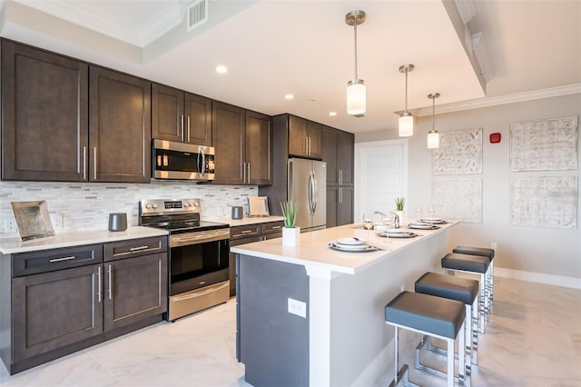 kitchen featuring pendant lighting, stainless steel appliances, a kitchen breakfast bar, dark brown cabinetry, and ornamental molding