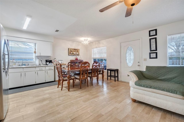 dining space featuring ceiling fan, sink, and light hardwood / wood-style flooring