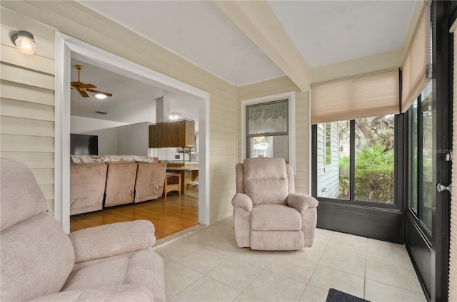 sunroom / solarium with ceiling fan and beam ceiling