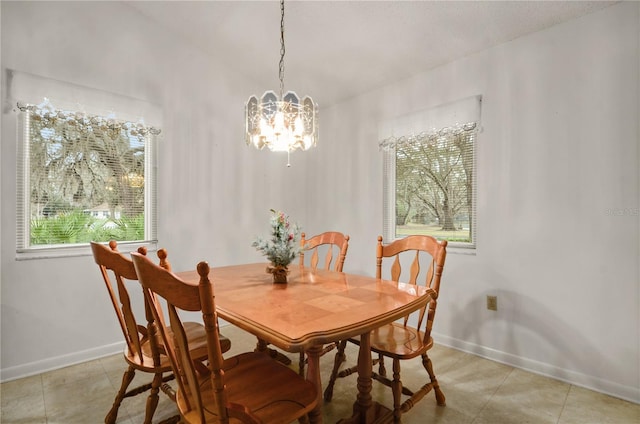 tiled dining area featuring a healthy amount of sunlight and a chandelier