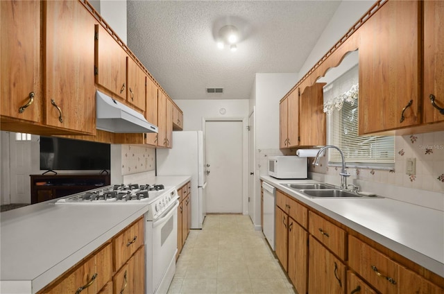 kitchen featuring sink, backsplash, a textured ceiling, and white appliances