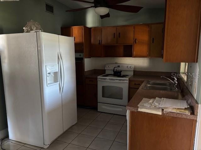 kitchen with light tile patterned flooring, white appliances, ceiling fan, and sink