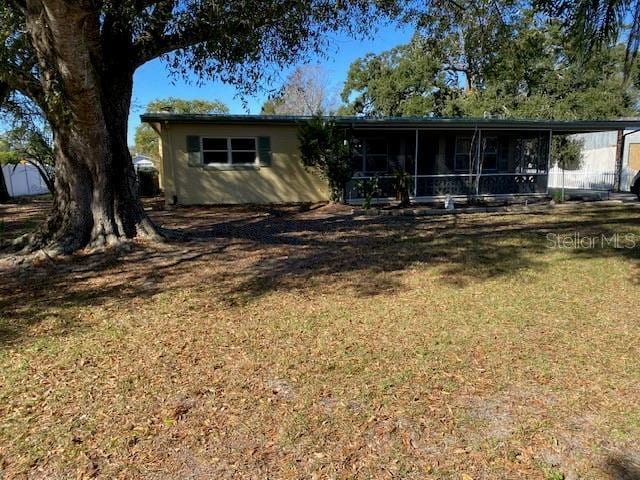 back of house featuring a sunroom and a yard