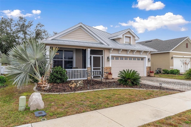 view of front of house with a garage, covered porch, and a front lawn