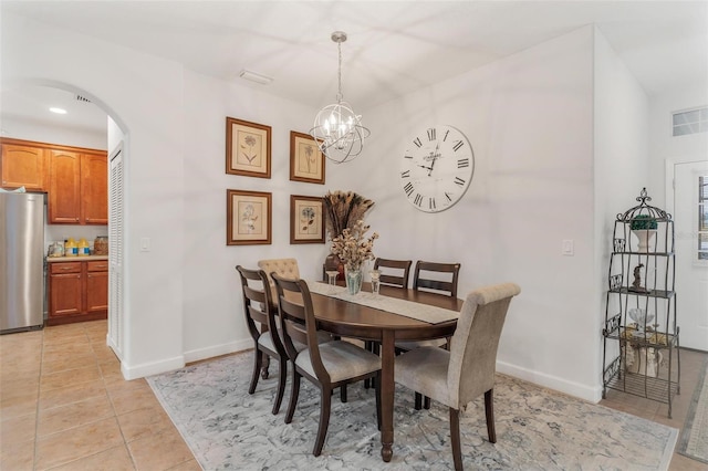 tiled dining room with an inviting chandelier