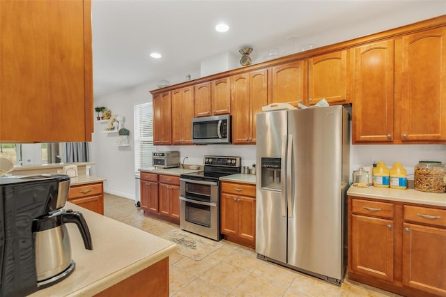 kitchen featuring stainless steel appliances and light tile patterned flooring