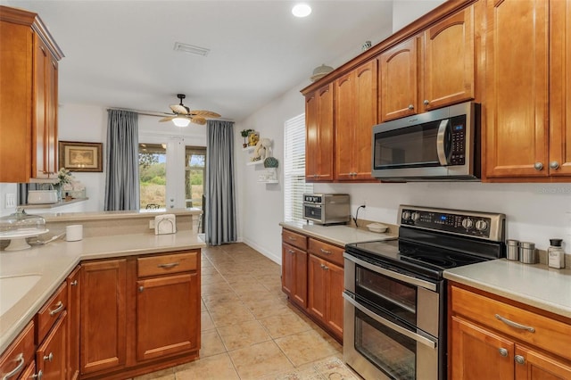 kitchen with light tile patterned floors, kitchen peninsula, ceiling fan, and appliances with stainless steel finishes