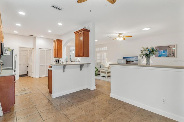 kitchen featuring appliances with stainless steel finishes, a breakfast bar area, ceiling fan, and kitchen peninsula