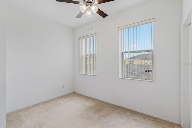 carpeted spare room with ceiling fan