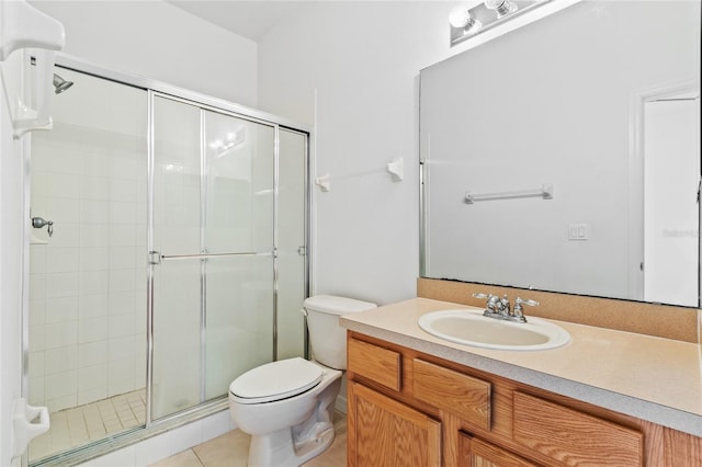 bathroom with tile patterned floors, toilet, a shower with shower door, and vanity