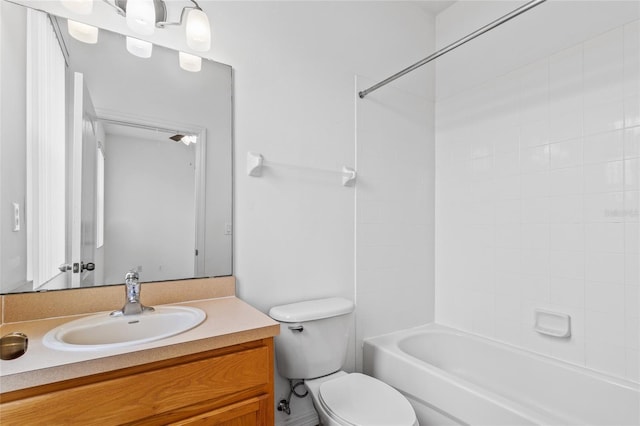 full bathroom featuring tiled shower / bath combo, vanity, and toilet