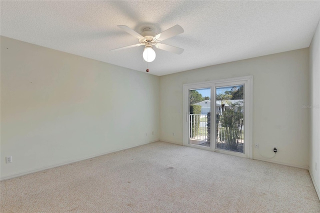 carpeted empty room featuring ceiling fan and a textured ceiling