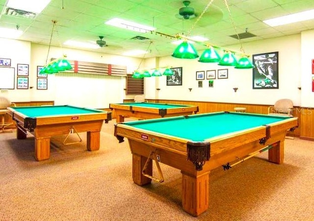 recreation room with a paneled ceiling, light carpet, pool table, and wood walls