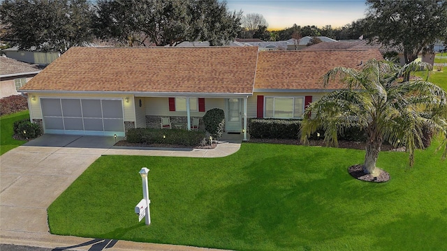 ranch-style house with a garage and a yard