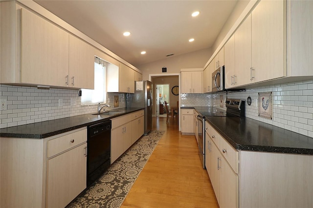 kitchen with sink, tasteful backsplash, vaulted ceiling, light hardwood / wood-style flooring, and stainless steel appliances