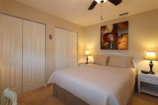 carpeted bedroom with multiple closets and ceiling fan