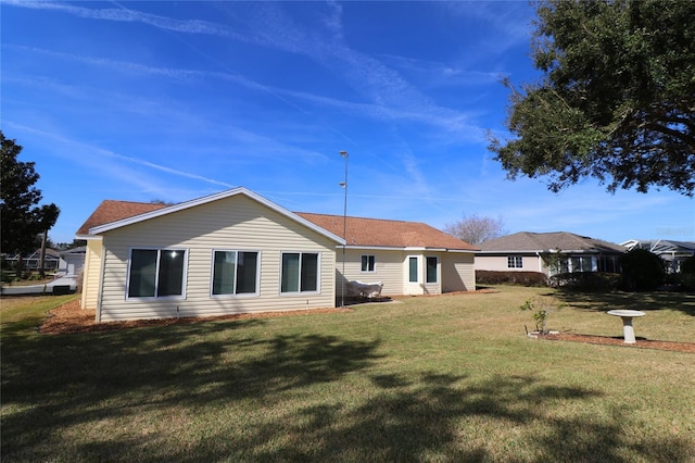 rear view of property with a yard