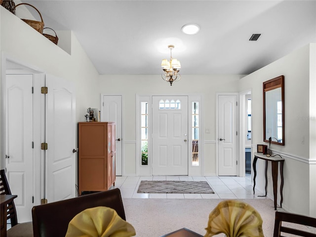 foyer entrance featuring an inviting chandelier and light tile patterned floors