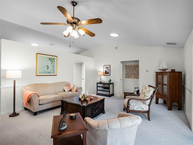 carpeted living room with ceiling fan and vaulted ceiling